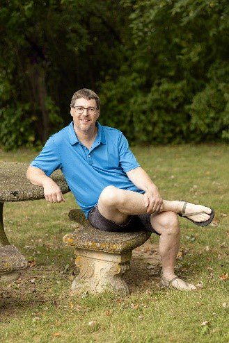 A man sitting on top of a stone bench.